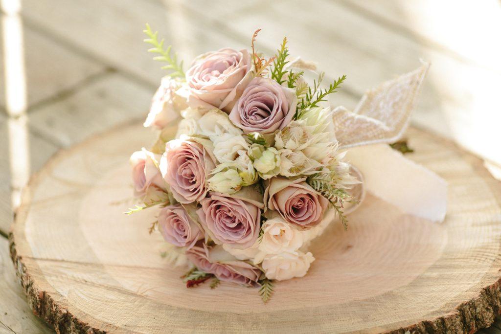 A bouquet of ivory and soft purple roses.