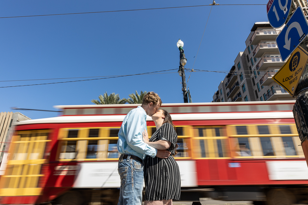 An couple kisses on Canal Street with the streetcar in the background. | Photos by Amin Russell Photography