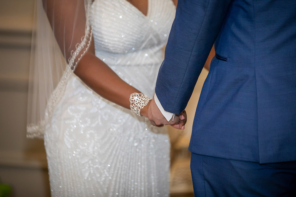 Kiara and Michael hold hands during their wedding ceremony. Photo: Brian Jarreau Photography