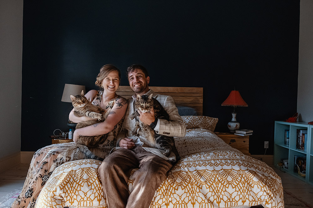Caitlin and Donald pose for a family portrait with their cats Buck and Roux.