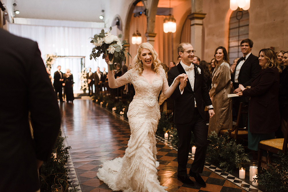 Chelsea and Ross celebrate as they walk down the aisle.
