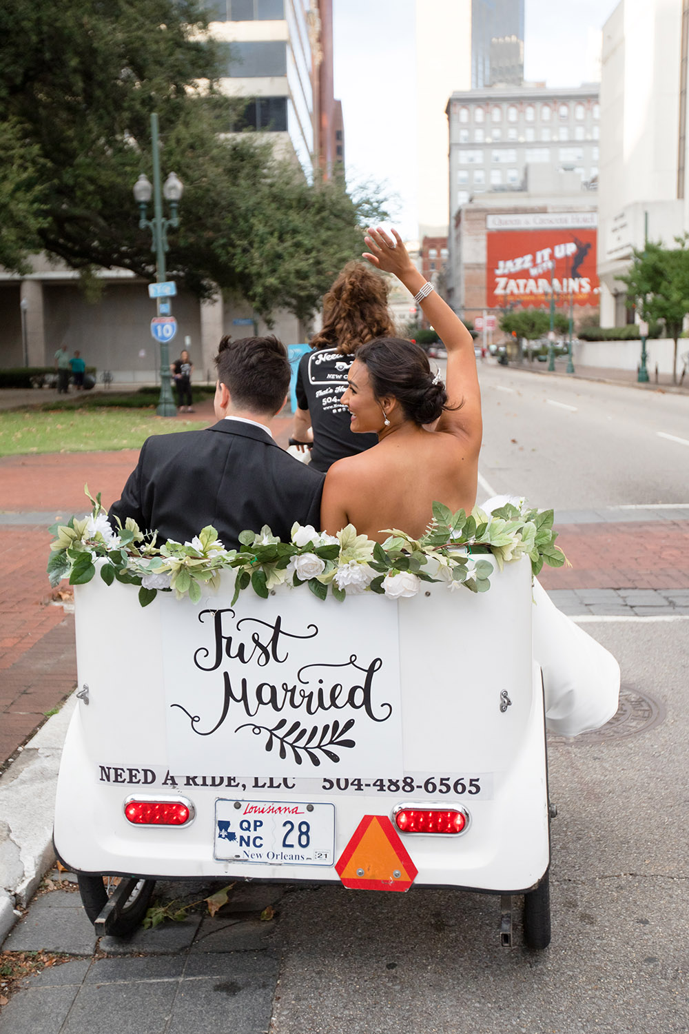 The bride and groom ride in a pedicab to their reception