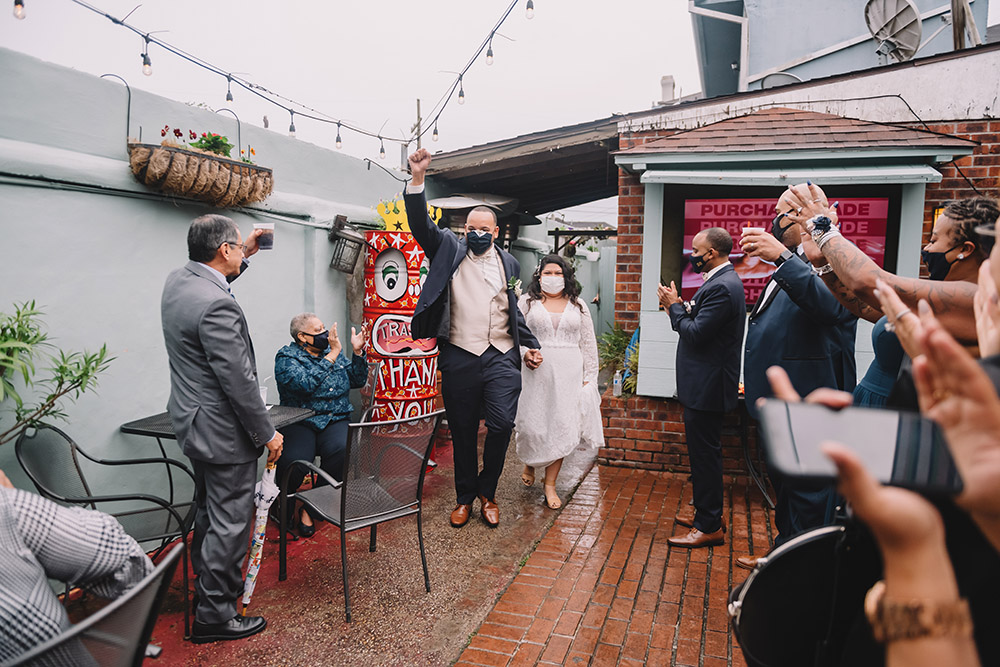 Ian and Mari enter the courtyard of Down the Hatch in New Orleans for their wedding reception. Photo by Rare Sighting Photography