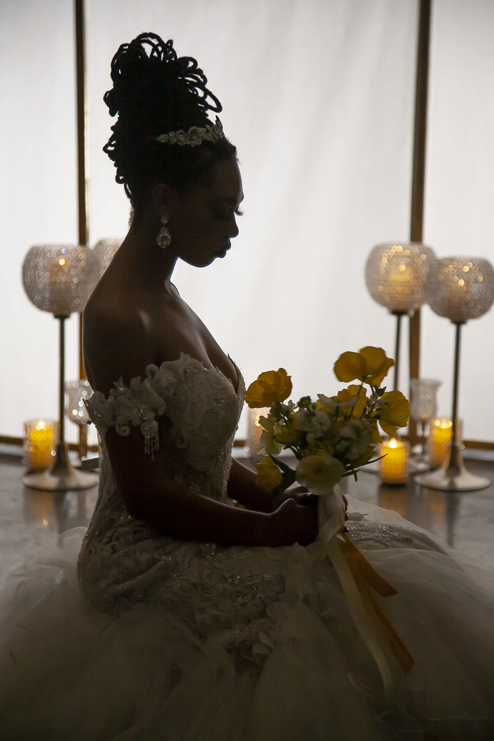 Silhouette of a bride gazing at her bouquet. Photo by Jessica Burke