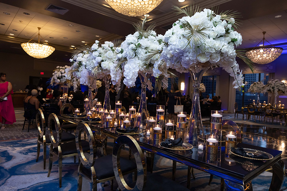 gold wedding reception table with white floral arrangements