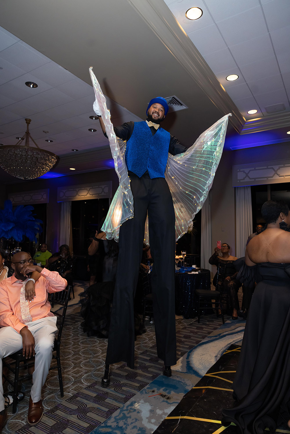 stilt walker with LED wings at the wedding reception