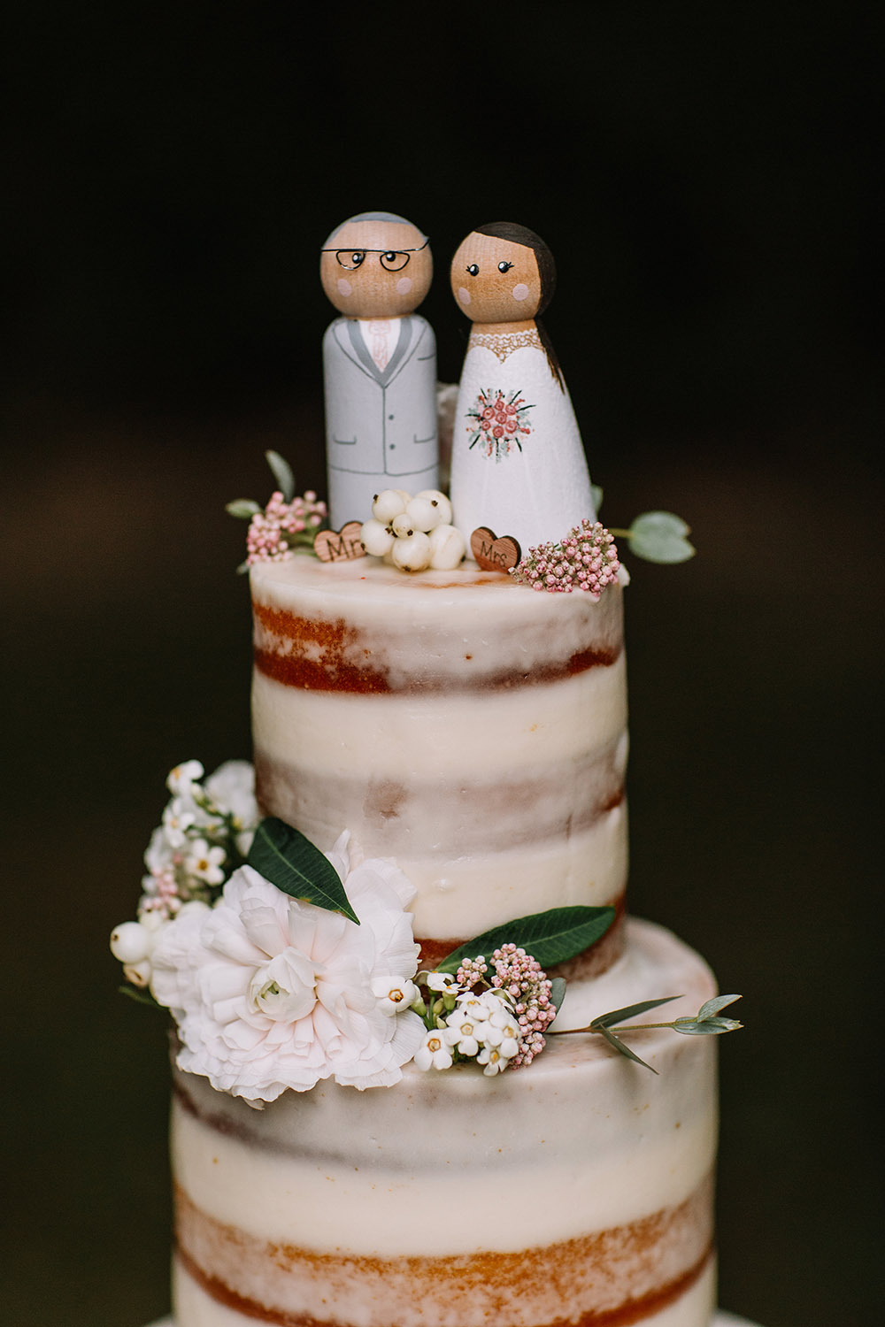 wedding cake with wooden bride and groom cake topper