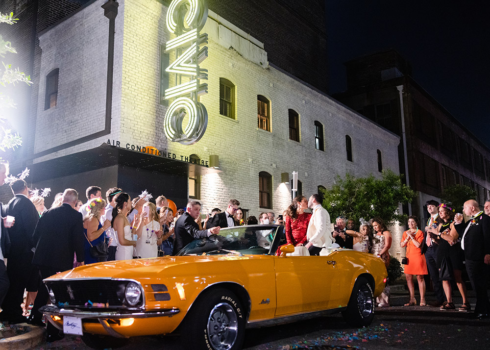 the newlyweds exit the reception in a 1970s Mustang Grabber Convertible