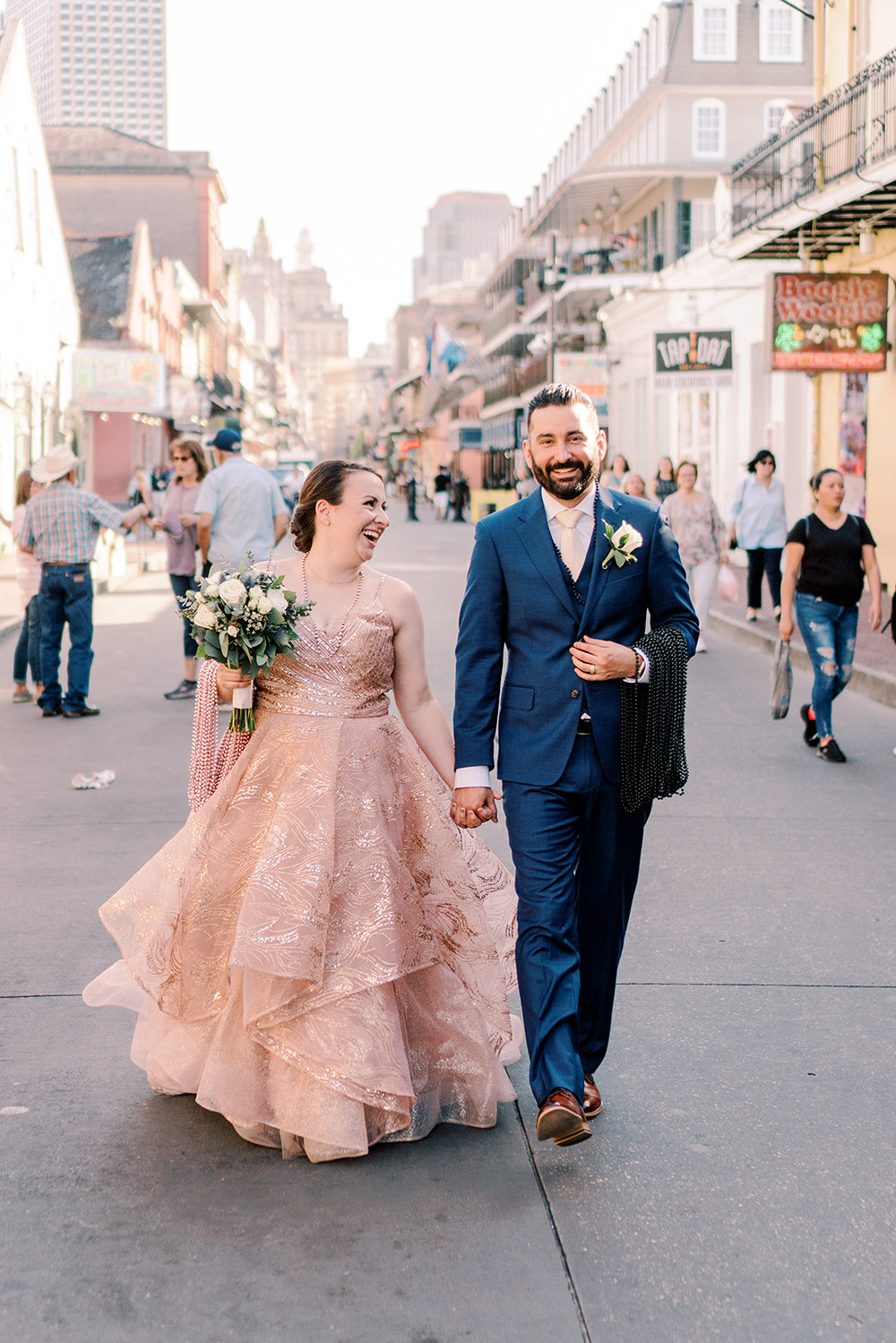 bride and groom walk down Bourbon Street