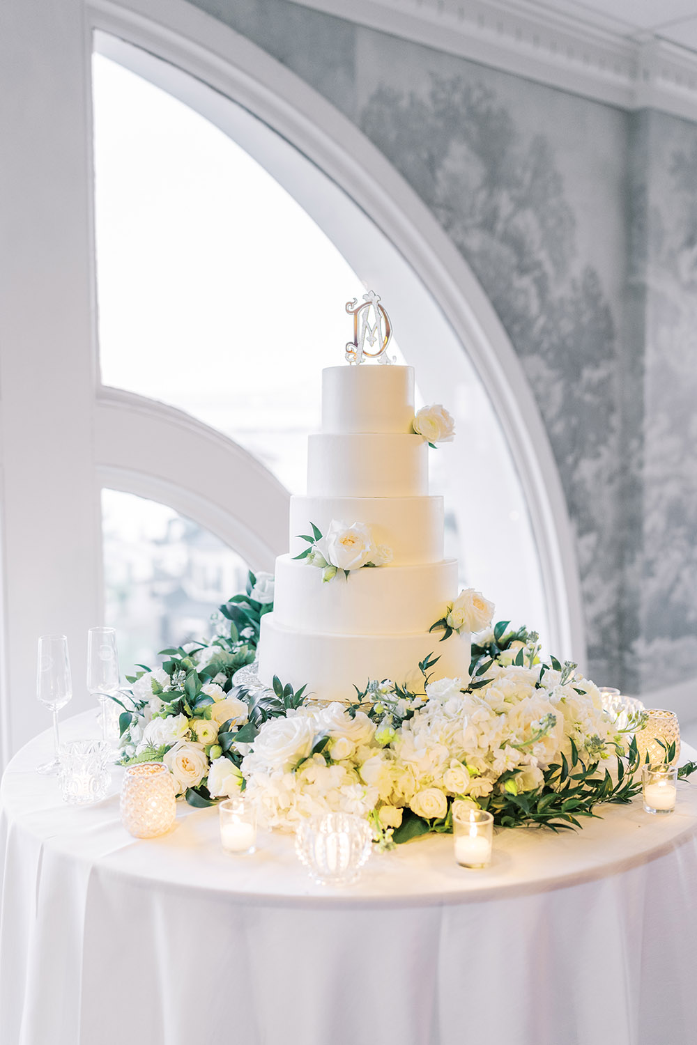 white wedding cake surrounded by flowers