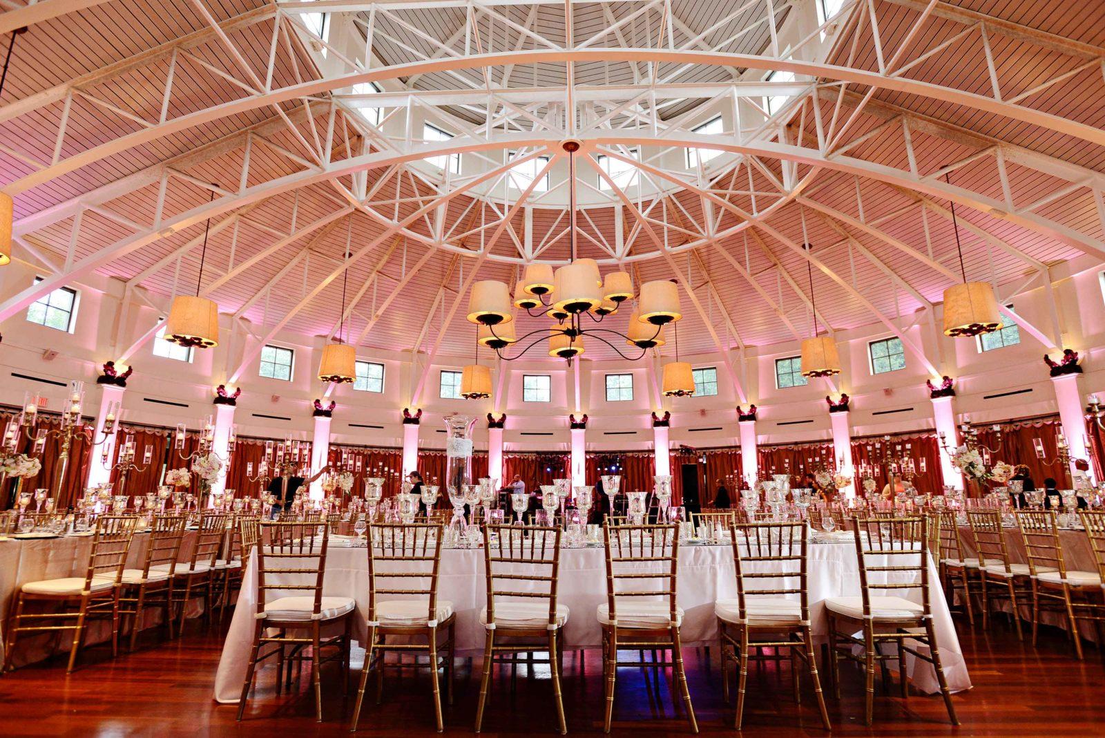 A wedding reception with pink up lights on the walls of the Audubon Tea Room. Photo: Studio Tran