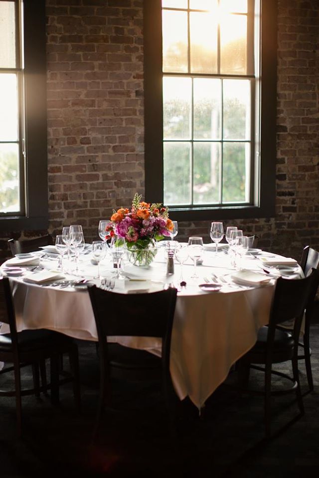 A reception table with colorful flowers awaits guests. Photo: Greer G Photography