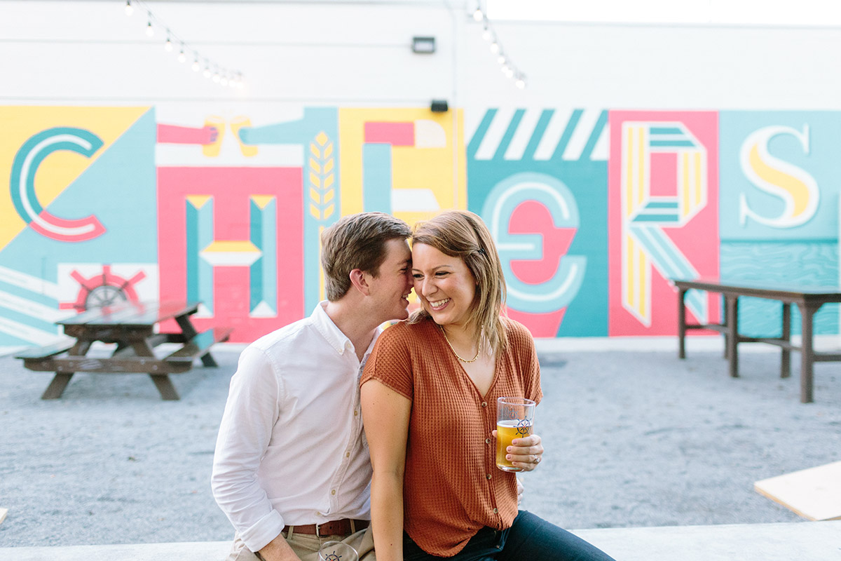 An engaged couple pose for photos at a beer garden. Photo: Sarah Alleman