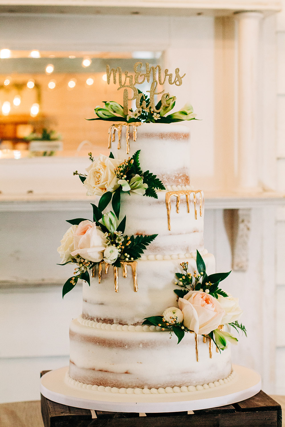 White "naked" cake with gold drip decoration and fresh flowers by Kimbla's Cakes | Photo by : Twisted Eye Photos