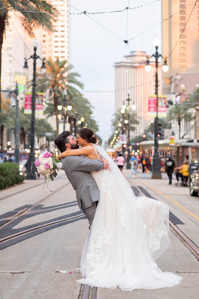 bride and groom kissing on Canal Streetcar line in New Orleans