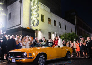 the newlyweds exit the reception in a 1970s Mustang Grabber Convertible