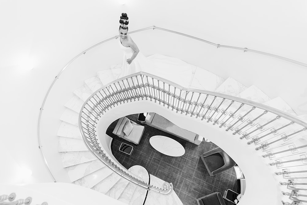 Black and white photo of bride on grand staircase by Amin Russell Photography