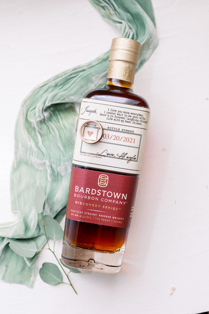 groom's gift bourbon bottle with wedding ring photo by sarah alleman photography