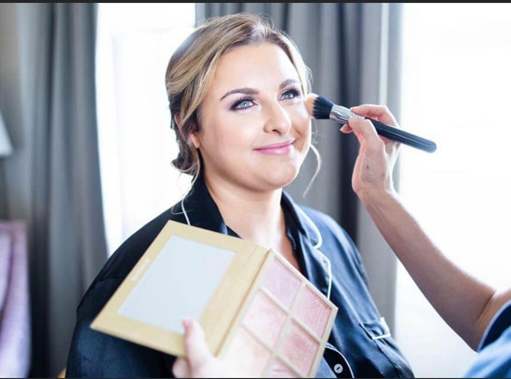 Bride getting her makeup done by About Face Cosmetics